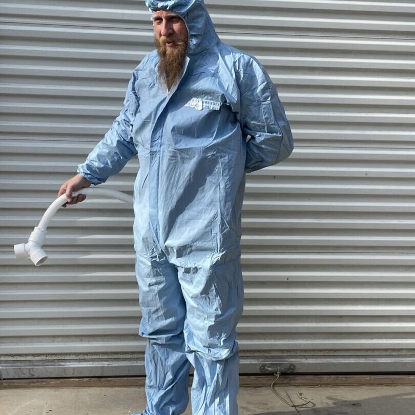 A man in blue coveralls and a white hat.